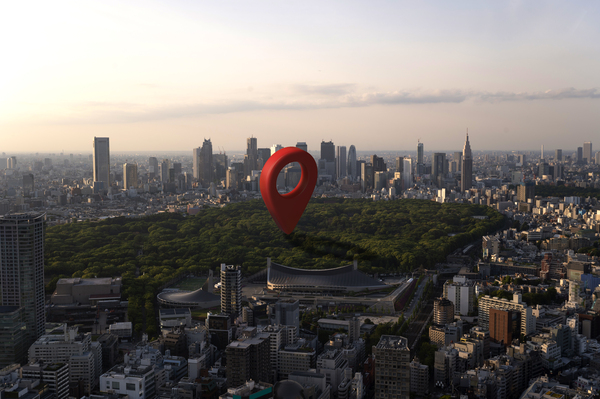 Aerial Tokyo With Red Map Pin Over A Green Park At Sunset